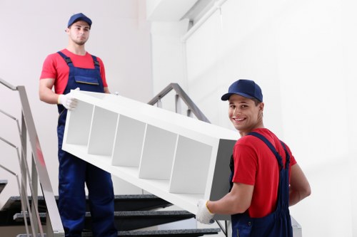 Professional furniture removals service in Camden preparing a sofa for transport